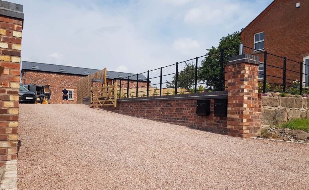 Large gravel driveway stretching the length of a new build house